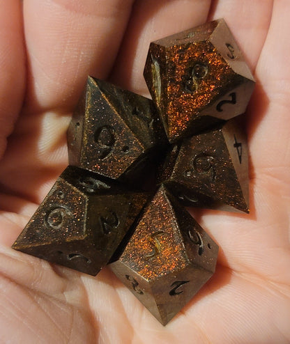 Hand holding ten-sided dice with rust-like textures